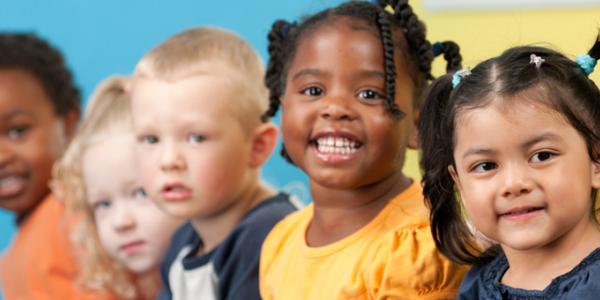 Five preschool children smiling at camera